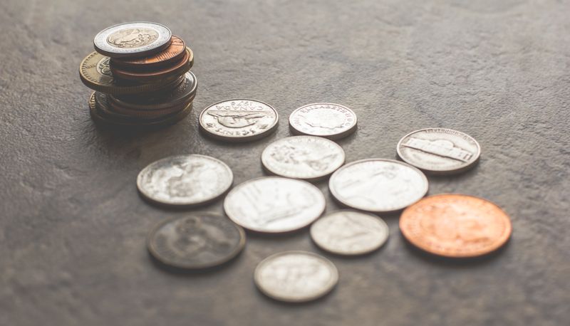 A few coins spread out on a grey table